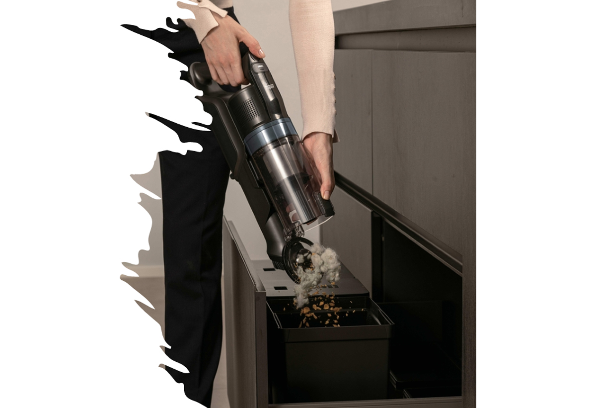 Μια γυναίκα αδειάζει τον κάδο της σκούπας.